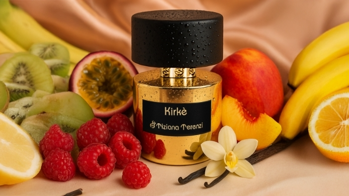 Goldener Parfumflakon ‚Kirke‘ zwischen Passionsfrucht, Pfirsichstücken, Himbeeren und Vanilleschoten vor beigefarbenem Stoff.
